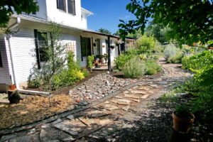 Another view of the stone walkway which leads to the front porch. Along side you'll find red salvia, a trellis with a climbing rose bush, and various flowering shrubs.